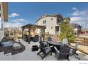 Inviting backyard with patio seating, a fire pit, and a beautifully landscaped garden area at 4877 Old River Ave, Firestone, CO 80504