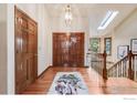 Inviting foyer features wood floors, double doors, and a decorative light fixture, leading to the staircase and upper levels at 5665 Cascade Pl, Boulder, CO 80303