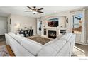 Comfortable living room with a fireplace, built-in shelving, and large windows that provide natural light at 6280 Snowberry Ave, Firestone, CO 80504
