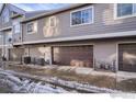 Attached garage with brown garage door, plus plenty of windows for light in this multi-story home at 6826 W 84Th Cir # 14, Arvada, CO 80003