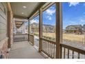 Cozy front porch featuring stone accents and community green space views at 7017 Kali Ct, Frederick, CO 80530