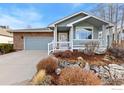 Well-kept home with a cozy front porch, rock garden landscaping, and a two-car garage at 742 Megan Ct, Longmont, CO 80504