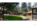 Serene backyard featuring a grassy lawn, mature trees, and a cozy outdoor seating area at 747 12Th St, Boulder, CO 80302