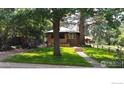 Inviting home exterior with lush green lawn, mature trees, and a classic brick facade at 747 12Th St, Boulder, CO 80302