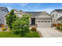 Charming home featuring a well-manicured front yard and an attached two-car garage at 892 Sundown Way, Erie, CO 80516