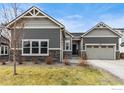 Beautiful single Gathering home features a two-car garage, stone accents, and manicured landscaping at 892 Sundown Way, Erie, CO 80516