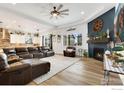 Open concept living room boasts hardwood floors, a fireplace and a smooth transition to the kitchen at 892 Sundown Way, Erie, CO 80516