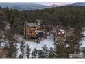 Beautiful aerial view of mountain home featuring a large deck and separate shed at 93 Hawk Ln, Boulder, CO 80304