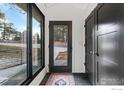 Modern entryway features a full-length window, sleek black door and coat closet at 93 Hawk Ln, Boulder, CO 80304