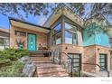 Up close view of the home's entryway with turquoise door, brickwork, and well-maintained landscaping at 955 Jasmine Cir, Boulder, CO 80304