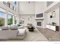Spacious living room with soaring ceilings, fireplace, and modern decor with outside view at 1863 Pioneer Cir, Lafayette, CO 80026