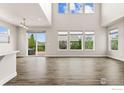 Sun-filled living room featuring tall windows, wood floors, and neutral wall colors at 1863 Pioneer Cir, Lafayette, CO 80026