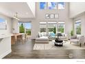 Bright living room with high ceilings, large windows, modern furniture, and access to the outdoor deck at 1863 Pioneer Cir, Lafayette, CO 80026