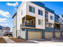 Contemporary townhomes with blue and white exteriors, featuring private balconies and garages at 12296 W 56Th Ln, Arvada, CO 80002