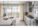 Gourmet kitchen with lake views, stainless steel appliances, and quartz countertops at 16568 W 92Nd Pl, Arvada, CO 80007