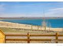 Scenic lake view featuring clear blue water and a distant cityscape under a bright sky at 16568 W 92Nd Pl, Arvada, CO 80007