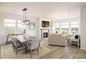 Bright living room featuring a fireplace, large windows with lake views, and modern furnishings at 16568 W 92Nd Pl, Arvada, CO 80007