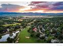 Panoramic aerial view of a golf course community with picturesque mountain views and sunset at 7155 Rustic Trl, Boulder, CO 80301