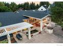 Gorgeous backyard features a stone fire pit and outdoor kitchen under a covered patio at 7155 Rustic Trl, Boulder, CO 80301