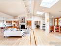 Spacious living room with fireplace, skylights, and beautiful hardwood floors at 7155 Rustic Trl, Boulder, CO 80301