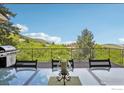 Covered outdoor deck with ample seating and a stunning view, creating a perfect setting for relaxation and entertainment at 10113 Thunder Run, Littleton, CO 80125