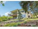 A view of the back of the home showing a multilevel deck and large windows overlooking a terraced yard at 10113 Thunder Run, Littleton, CO 80125