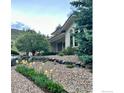 Landscaped front yard with gravel, garden bed, and mature trees in a well-maintained setting at 10113 Thunder Run, Littleton, CO 80125