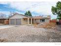 Single-story home featuring a two-car garage, brick facade, and solar panels at 1410 Oak Dr, Berthoud, CO 80513