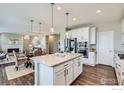 Open-concept kitchen featuring an island, stainless appliances, and seamless flow to dining and living areas at 38 Morgan S Cir, Erie, CO 80516