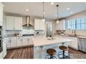 Bright kitchen with white cabinets, stainless steel appliances, and a central island with barstool seating at 38 Morgan S Cir, Erie, CO 80516