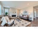 Cozy living room featuring a stone fireplace, plush seating, and a stylish area rug on hardwood flooring at 38 Morgan S Cir, Erie, CO 80516