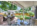 Outdoor patio with comfortable seating, a glass table, and a view of the well-maintained backyard and fence at 721 Concord Ave, Boulder, CO 80304