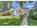 Inviting two-story home with a covered front porch, lush lawn, and manicured garden beds under a sunny sky at 721 Concord Ave, Boulder, CO 80304
