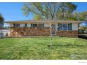 Well-kept front yard with a charming single-story home and mature trees at 2 Lincoln Pl, Longmont, CO 80501