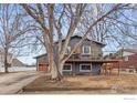 Charming two-story home with a gray exterior and a deck, enhanced by a large tree in the front yard at 229 Berwick Ave, Firestone, CO 80520