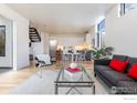 Modern living room with hardwood floors, a gray sofa with red pillows, and an open kitchen at 2304 Pearl St # 2, Boulder, CO 80302