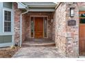 Welcoming front entryway with brick facade and stylish, modern lighting fixture at 2345 Spotswood Pl, Boulder, CO 80304