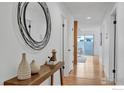 Bright hallway with a console table, decorative mirror and light hardwood floors at 4248 Corriente Pl, Boulder, CO 80301