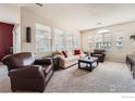 Cozy living room with neutral tones, large windows, comfortable seating, and carpet flooring at 122 Whitehaven Cir, Highlands Ranch, CO 80129