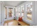 Bright and airy sunroom with large windows, wood bench, and glass front door at 1282 S Sherman St, Denver, CO 80210