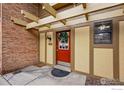 Charming condo entrance featuring a red door, decorative wreath, and well-lit address display at 3000 Colorado Ave # 124, Boulder, CO 80303