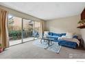 Bright living room with sliding glass doors, a blue sofa, and cozy rug at 3000 Colorado Ave # 124, Boulder, CO 80303