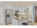 Modern kitchen boasting stainless steel appliances, white cabinets, and center island with a breakfast bar and stool at 3401 Arapahoe Ave # 315, Boulder, CO 80303