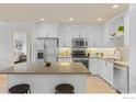 Well-equipped kitchen with stainless steel appliances, sleek white cabinetry, and center island with bar stool seating at 3401 Arapahoe Ave # 315, Boulder, CO 80303