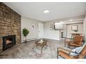 Living room featuring a stone fireplace, wood-look floors, and modern furnishings at 10150 E Virginia Ave # 106, Denver, CO 80247