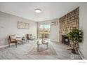 Living room features a stone fireplace, wood-look floors, and a sliding glass door leading to a patio at 10150 E Virginia Ave # 106, Denver, CO 80247