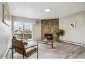 Bright living room featuring a stone fireplace, wood-look floors, and a sliding glass door to the exterior at 10150 E Virginia Ave # 106, Denver, CO 80247