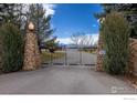 Private drive gated entry with stone pillars and mature landscaping at 10391 E Goose Haven Dr, Lafayette, CO 80026