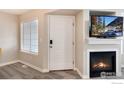 Cozy living room featuring a fireplace, television, and ample natural light from the adjacent window at 1419 Red Mountain Dr # 15, Longmont, CO 80504