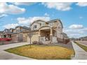 Attractive two-story home featuring a well-maintained lawn, covered porch, and neutral color palette at 17995 E 107Th Pl, Commerce City, CO 80022